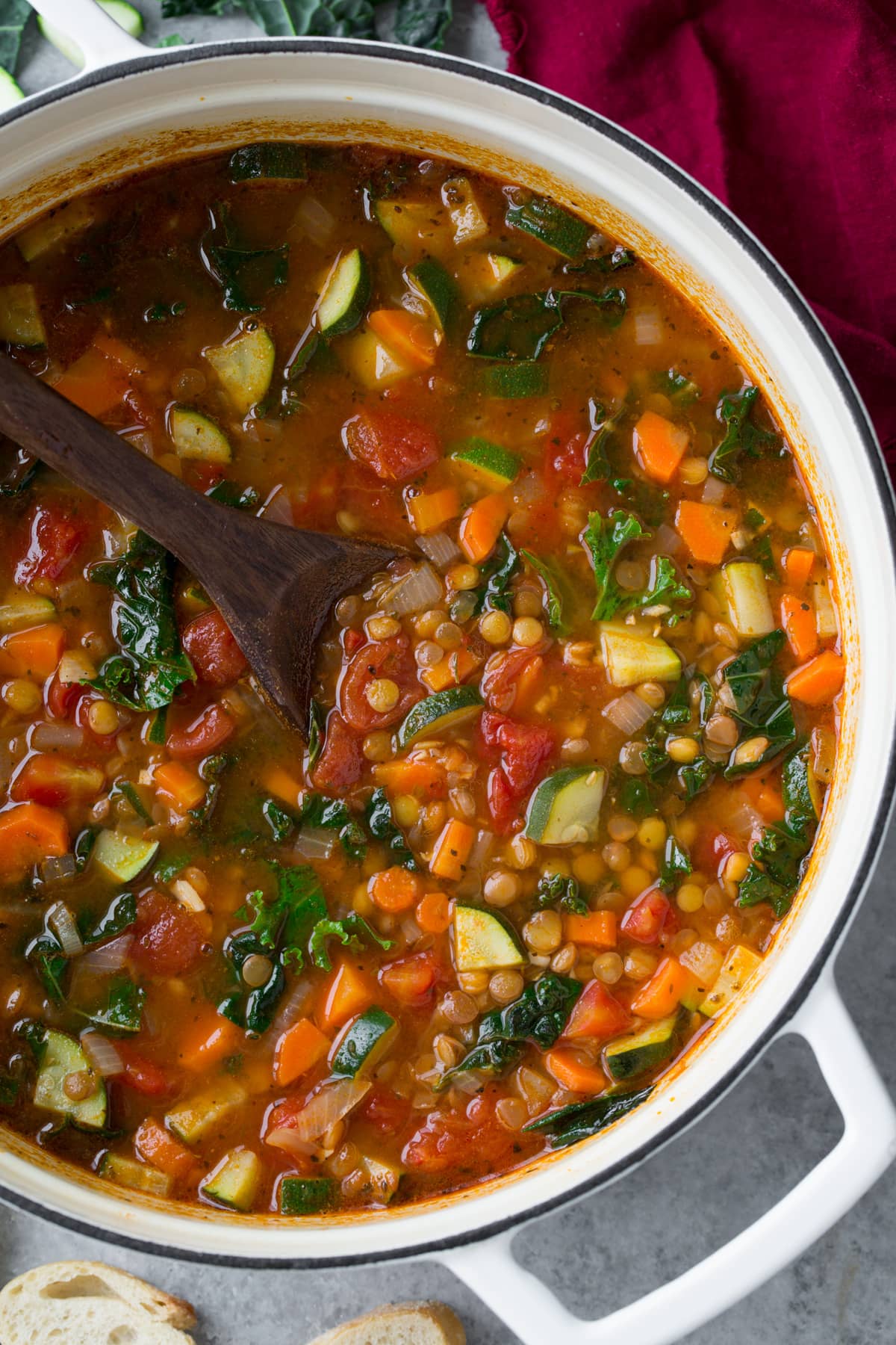 Lentil Soup in a white pot with a wooden spoon