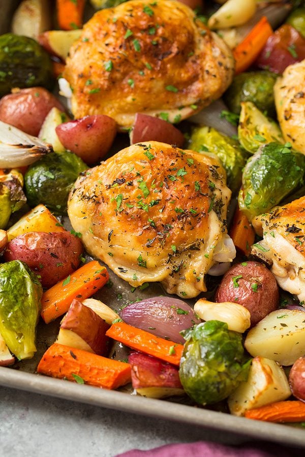 Sheet Pan Roasted Chicken and Veggies Close up image of baked chicken thigh with vegetables.