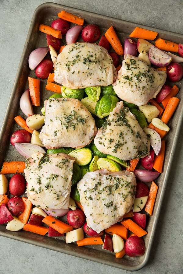Sheet Pan Roasted Chicken and Root Vegetables Chicken and veggies on baking sheet before baking.