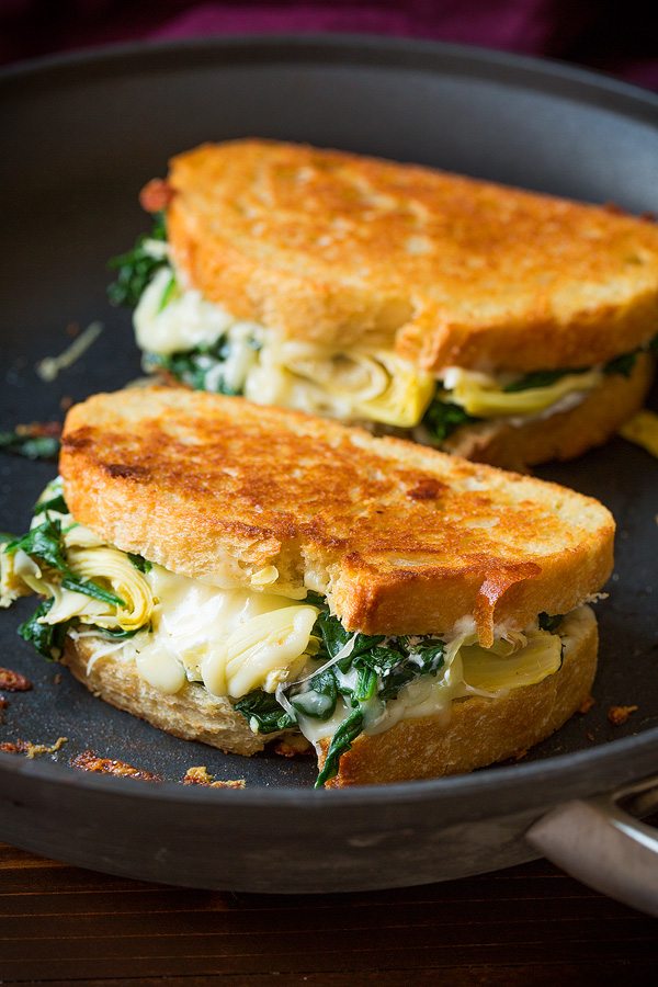 Spinach Artichoke Grilled Cheese Sandwich Two grilled cheese sandwiches in skillet.
