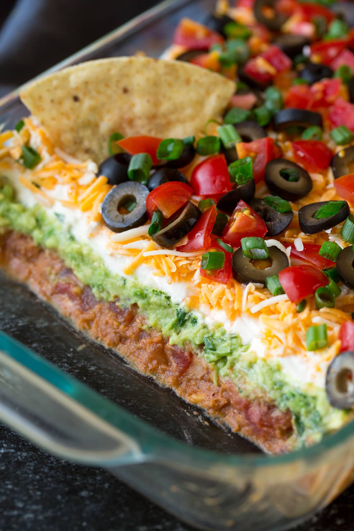 7 Layer Bean Dip - one of the all time best party foods! This stuff is addictive! #7layerdip #dip #appetizer #snack #partyfood Close up image of 7 layer dip showing all the separate layers.