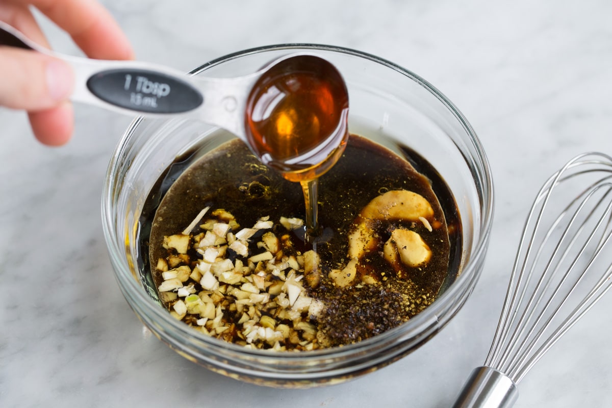 Best Steak Kebabs Showing how to make a kebab marinade, whisking liquid ingredients in a glass mixing bowl.