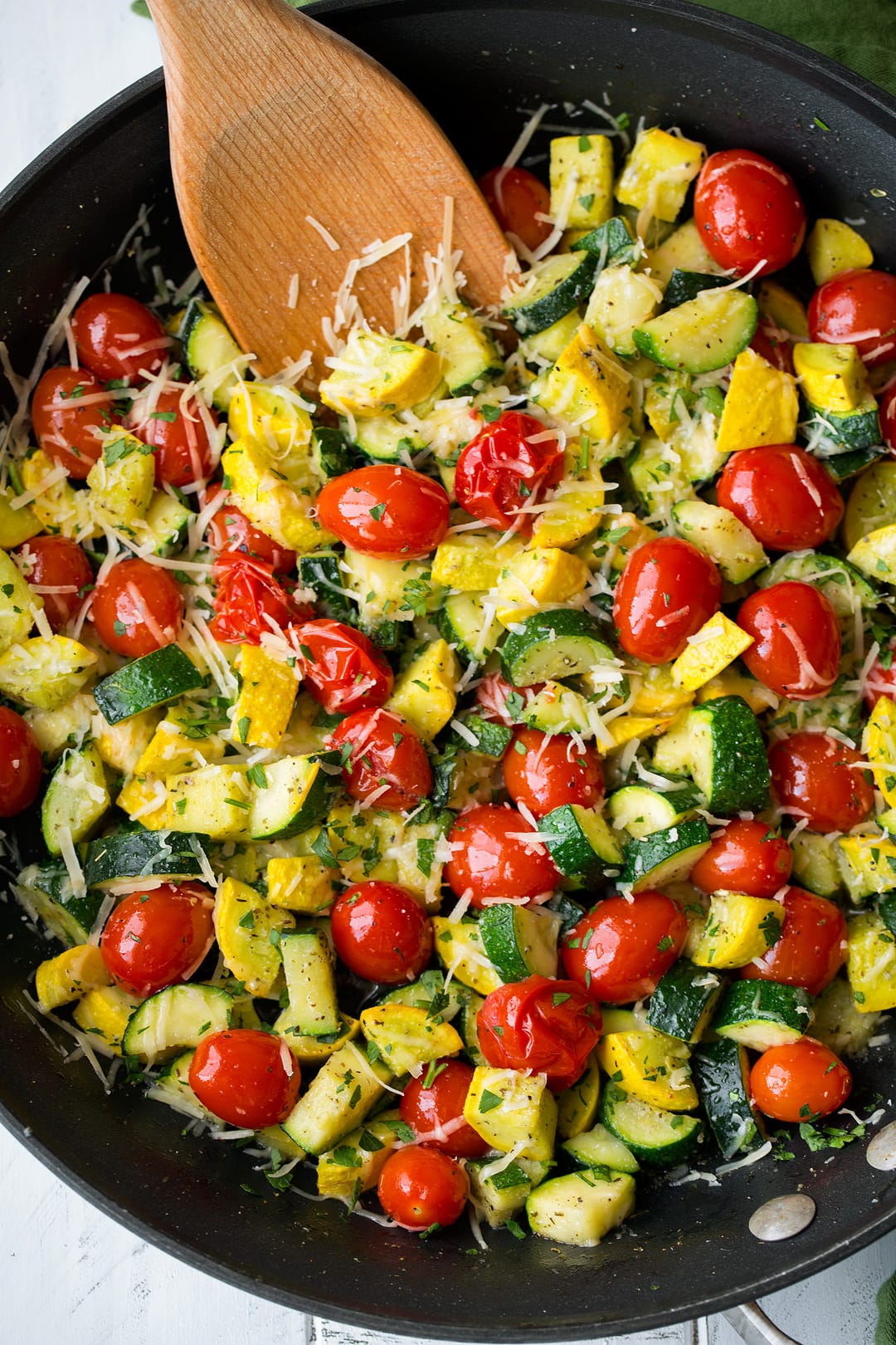 Garlic Parmesan Zucchini Squash and Tomatoes Overhead image of sauteed zucchini, squash and tomatoes in a large dark skillet.
