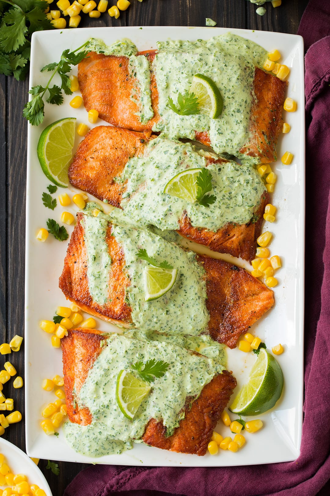 four cilantro lime salmon fillets on white platter