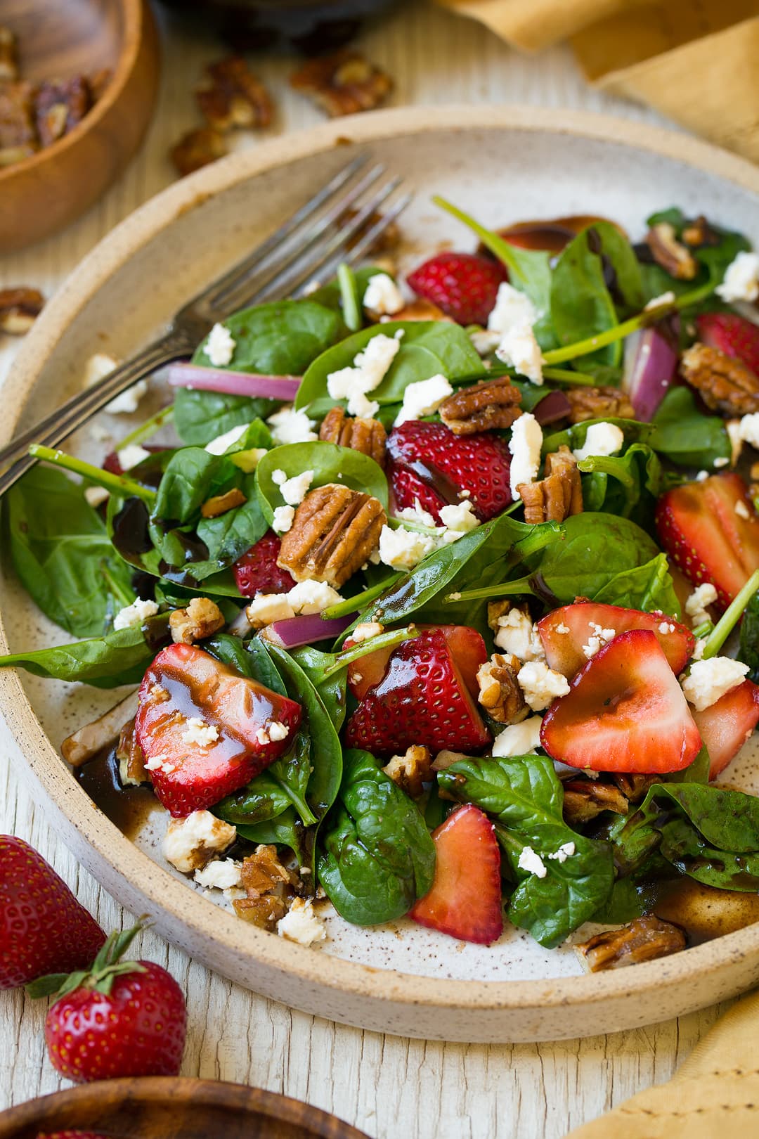 Strawberry Spinach Salad. An easy and delicious spinach salad made with strawberries, feta, candied pecans and a balsamic vinaigrette. | Strawberry Salad | Summer Salads | Easy Salads | #cookingclassy #spinach #strawberry #salad A Strawberry Spinach Salad in a bowl with a fork
