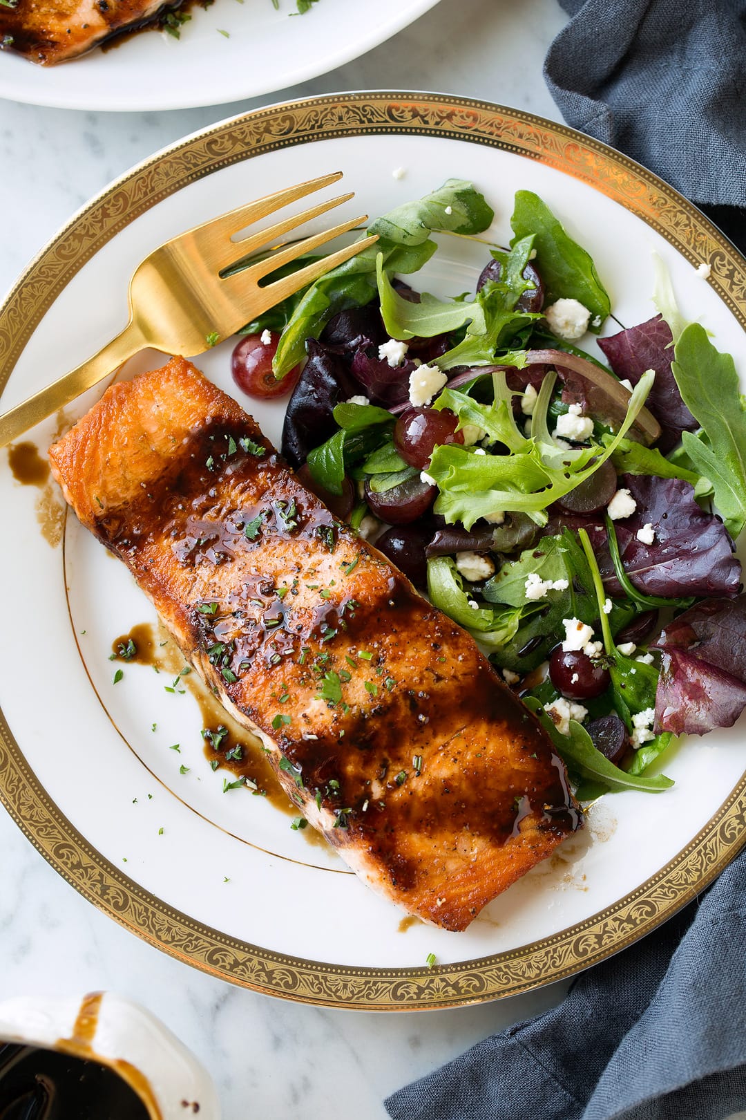 Balsamic Glazed Salmon fillet on white plate with green salad
