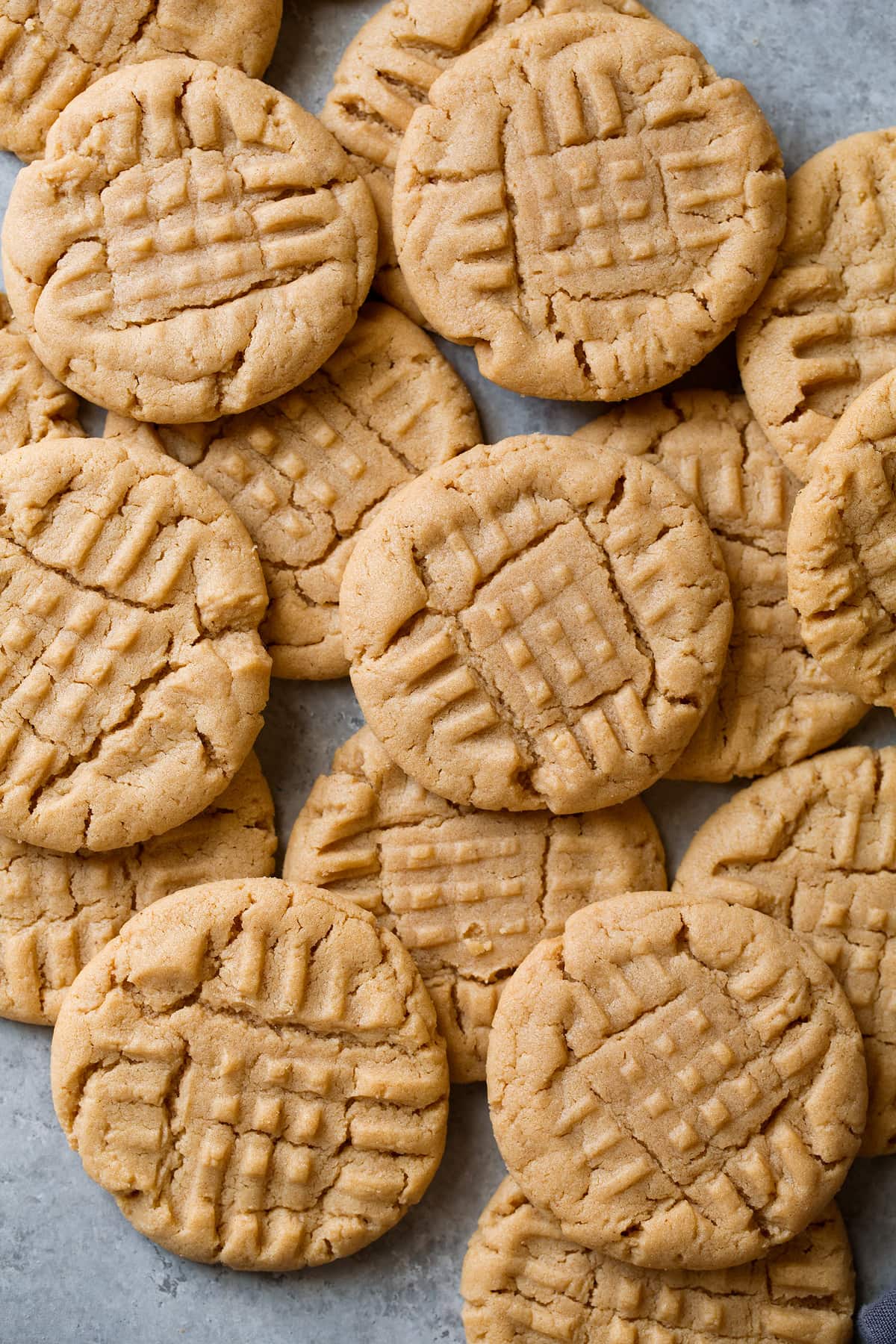 Peanut Butter Cookies Homemade Peanut Butter Cookies stacked on a grey surface.