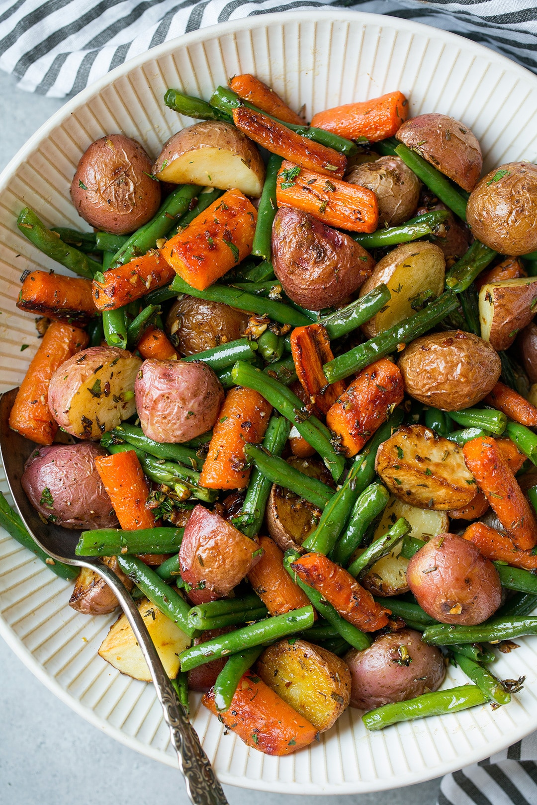 Roasted Vegetables including potatoes carrots and green beans with garlic herb seasoning.