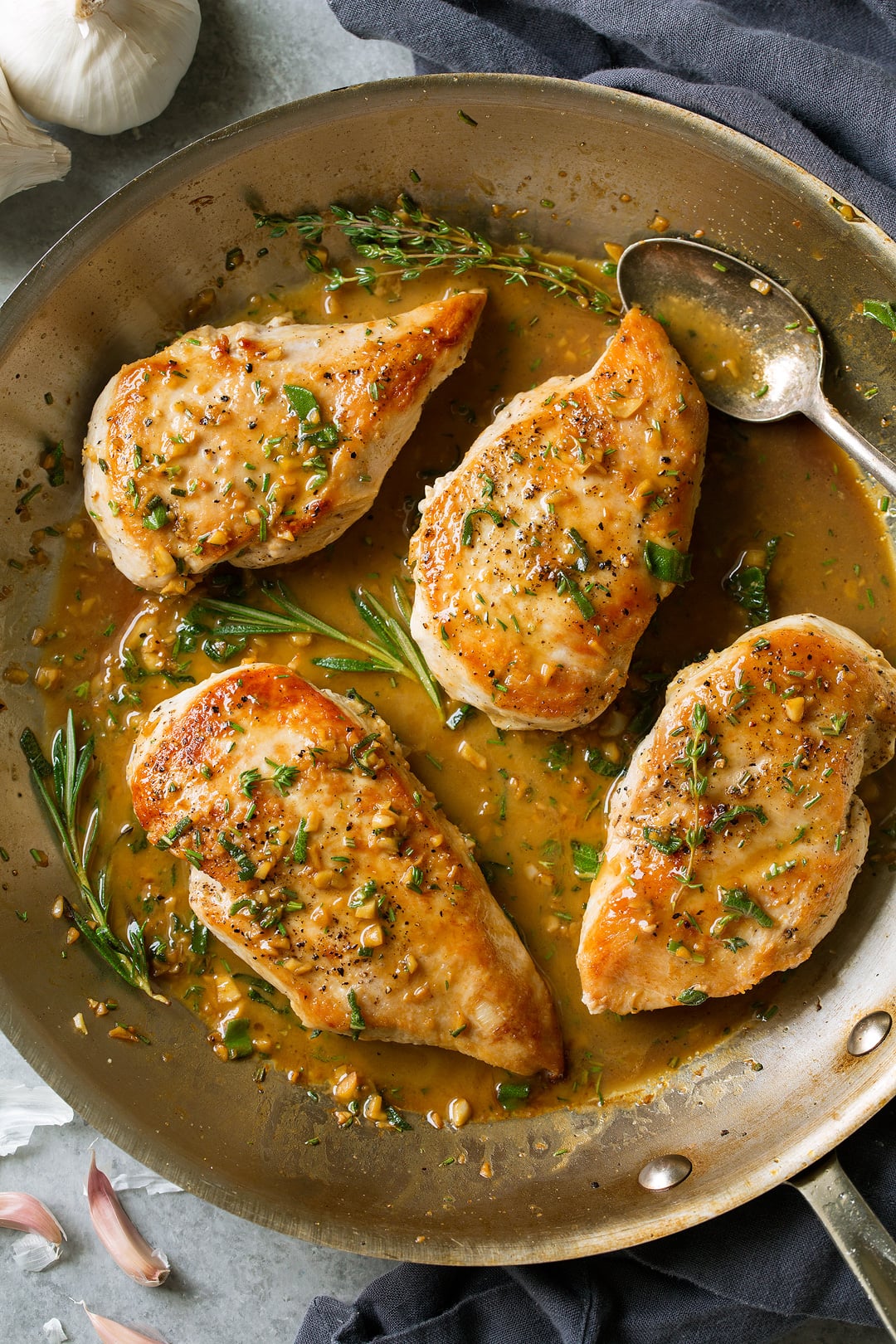 Super quick and easy seared skillet chicken topped with a delicious garlic and herb pan sauce that's sure to please! A perfect chicken recipe for busy weeknights. | Chicken Dinner | Chicken Recipes | Weeknight Meals | #cookingclassy #chicken #sauce #butter Skillet Chicken with Garlic Herb Butter Sauce in a skillet pan with a spoon