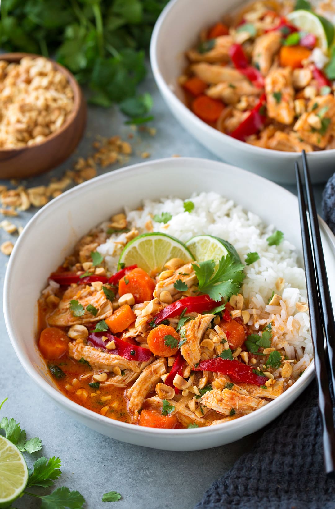 Thai Chicken Curry. A delicious and satisfying Thai chicken curry made in the slow cooker. There's minimal effort required to make this chicken curry and maximum flavor! Serve with rice. | Easy Chicken Curry | Slow Cooker Curry | #cookingclassy #curry #Thaifood #chicken Thai Chicken Curry in a bowl with black chopsticks at the side