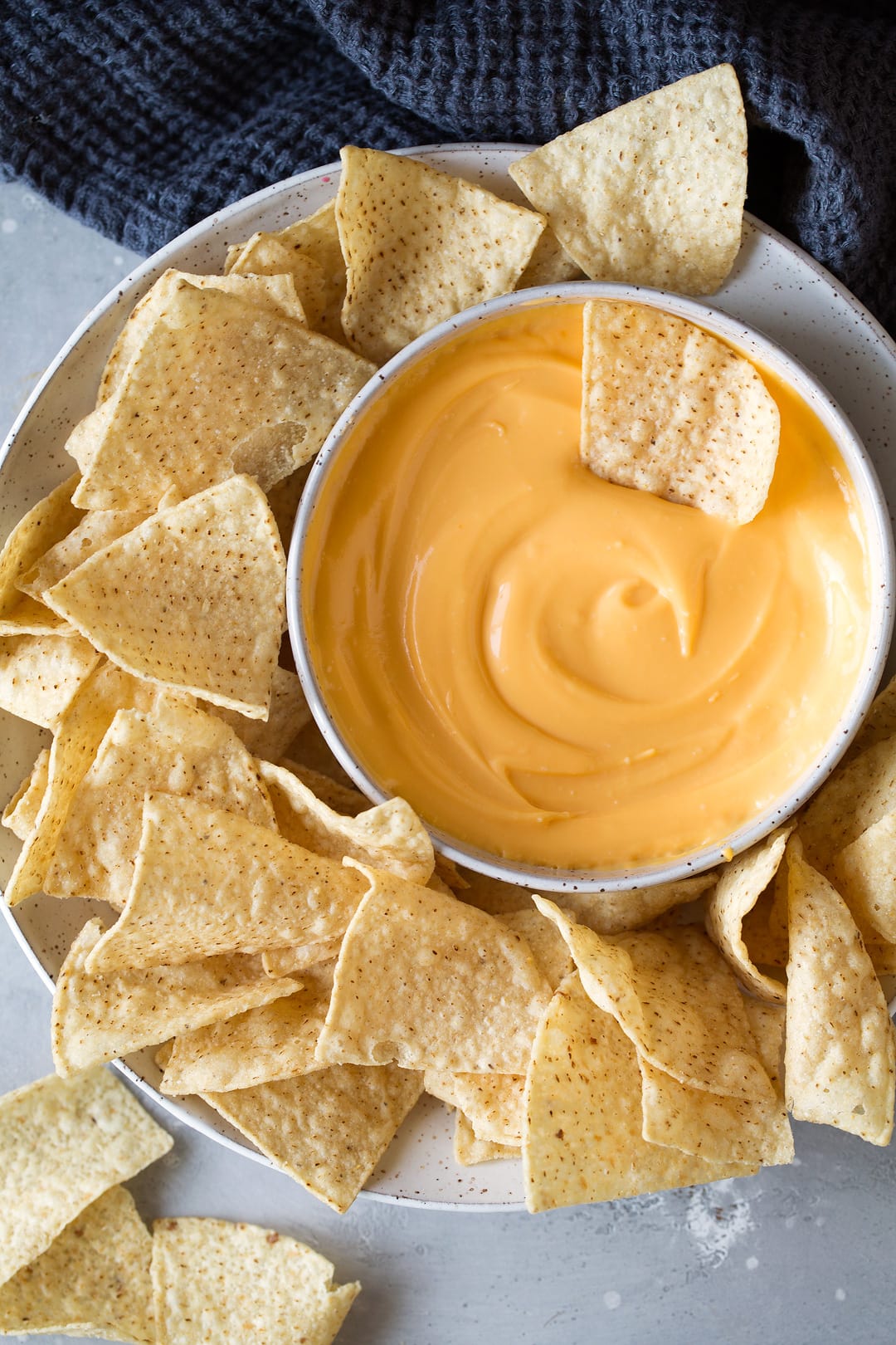3 Ingredient Cheese Dip bowl of cheddar cheese dip on a plate with tortilla chips