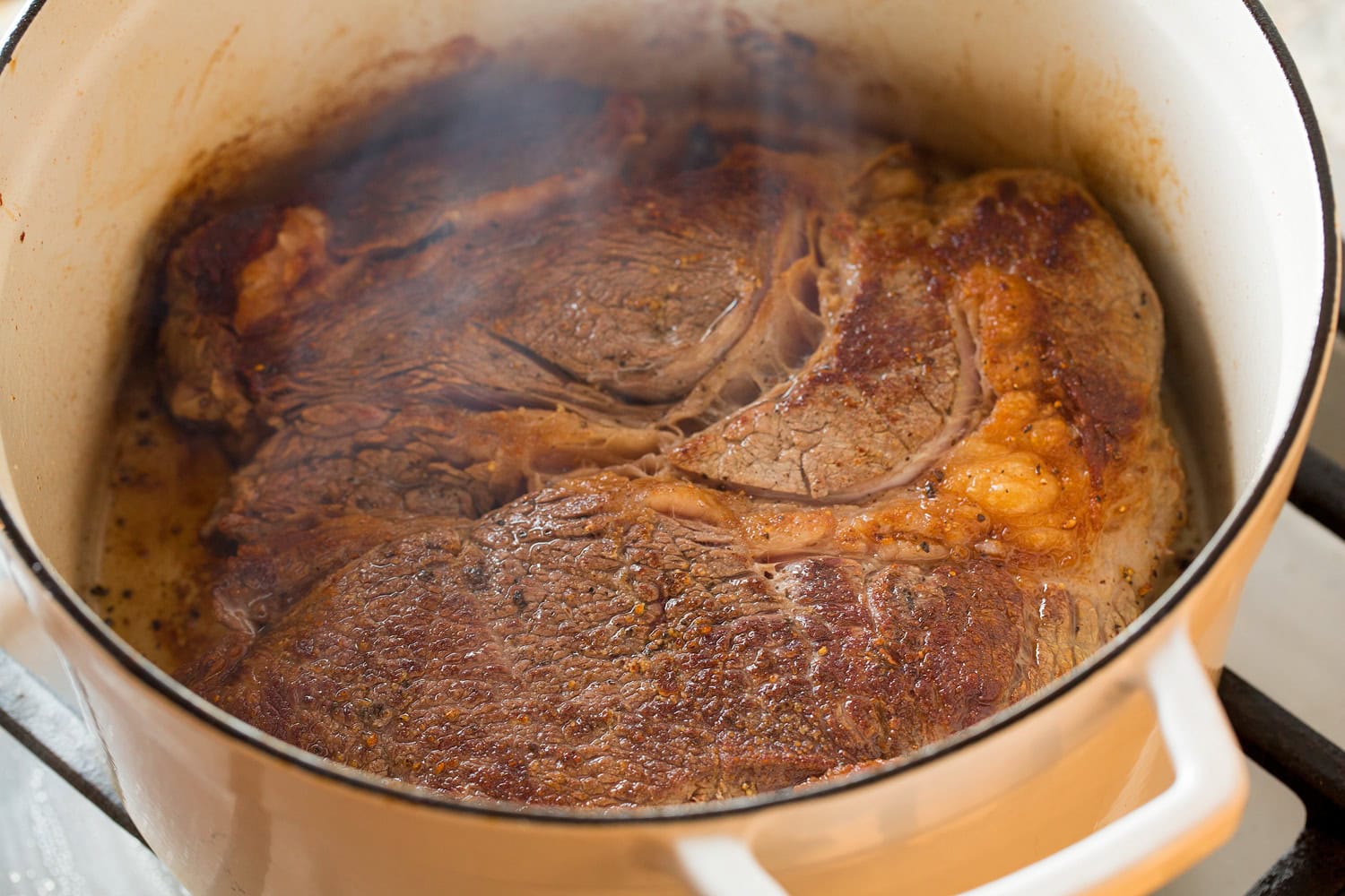 Shredded Beef Tacos Seared chuck roast in a large pot.
