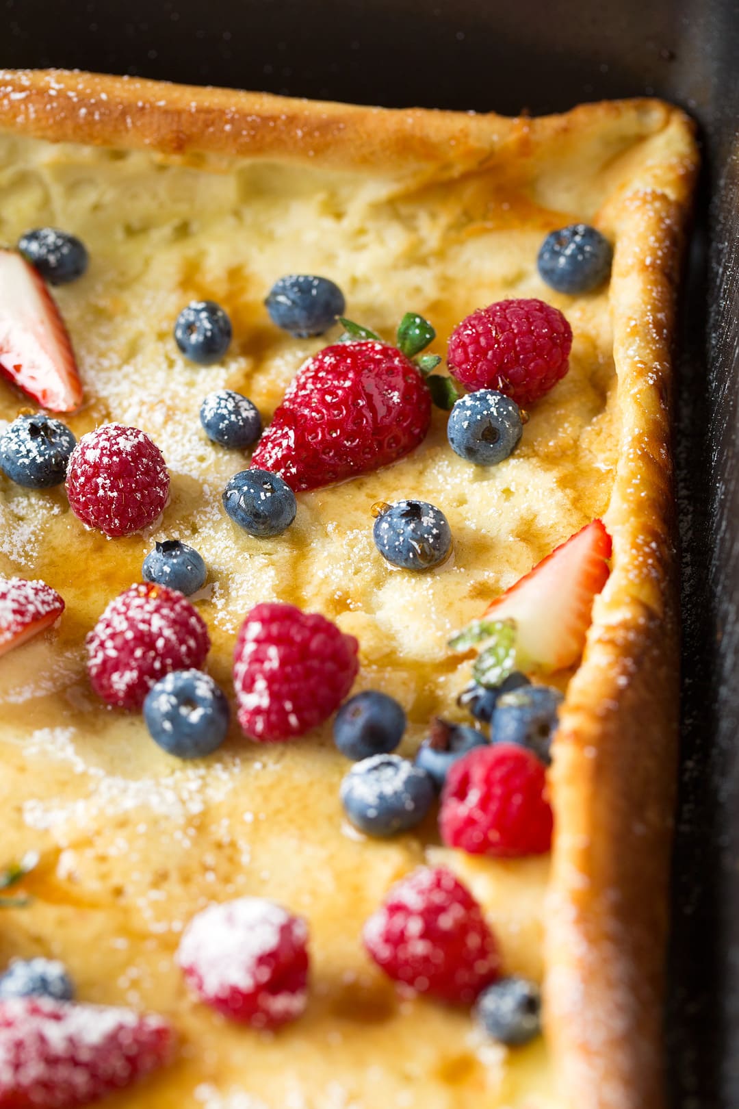 German pancake in baking pan topped with fresh fruit