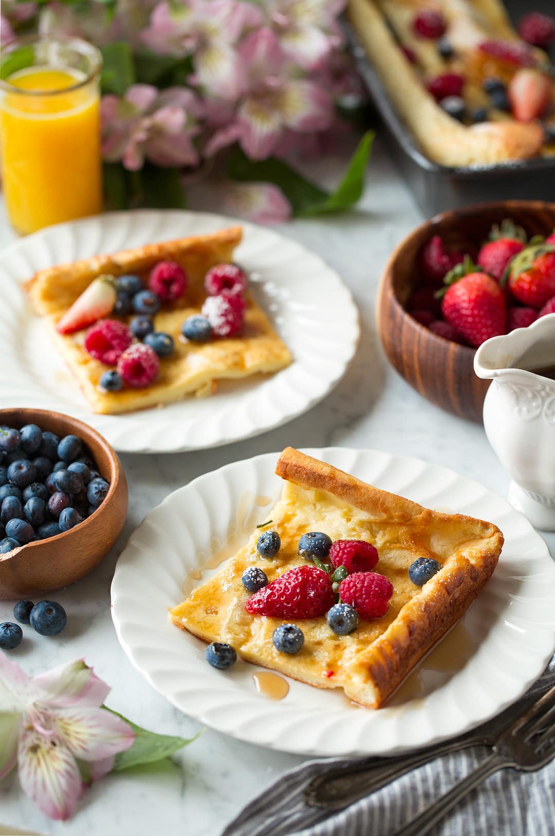German Pancake slices on white plates with fresh fruit