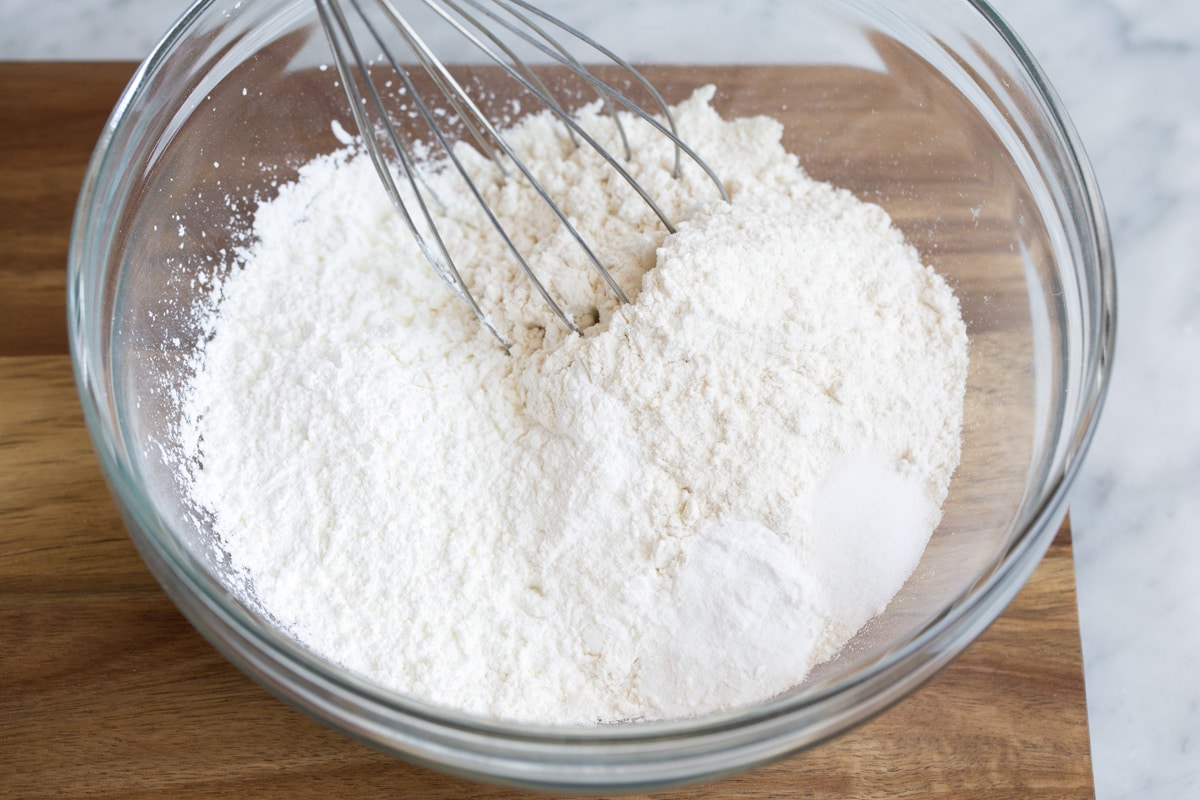 How to Make Perfect Belgian Waffles - with step by step instructions! These are easily the best waffles you'll try! Light and fluffy and tender inside and deliciously crisp outside. #belgian #waffles #breakfast Showing how to make belgian waffle batter. Starting here by whisking dry ingredients in a glass mixing bowl.