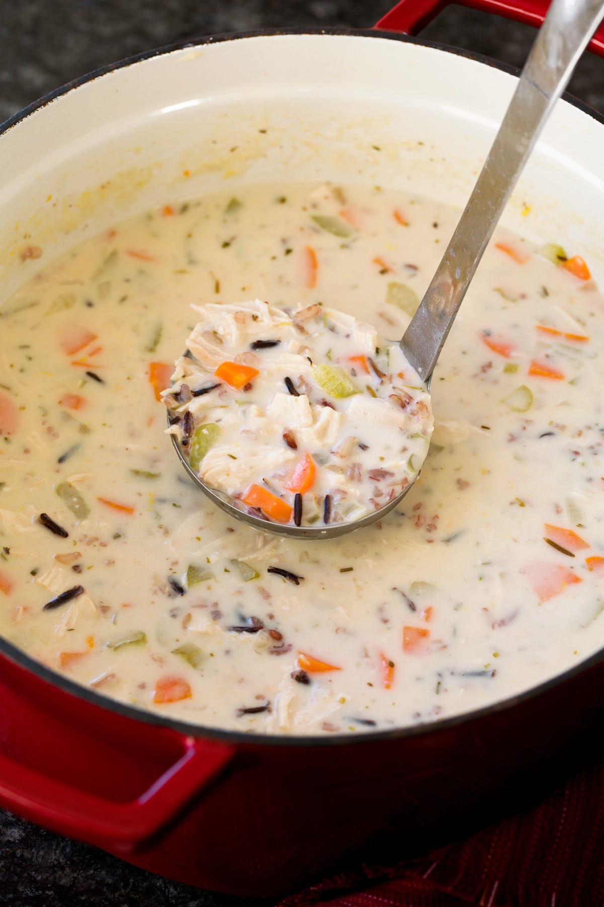 Creamy Chicken and Wild Rice Soup Chicken and wild rice soup in a pot with ladle full being scooped out.