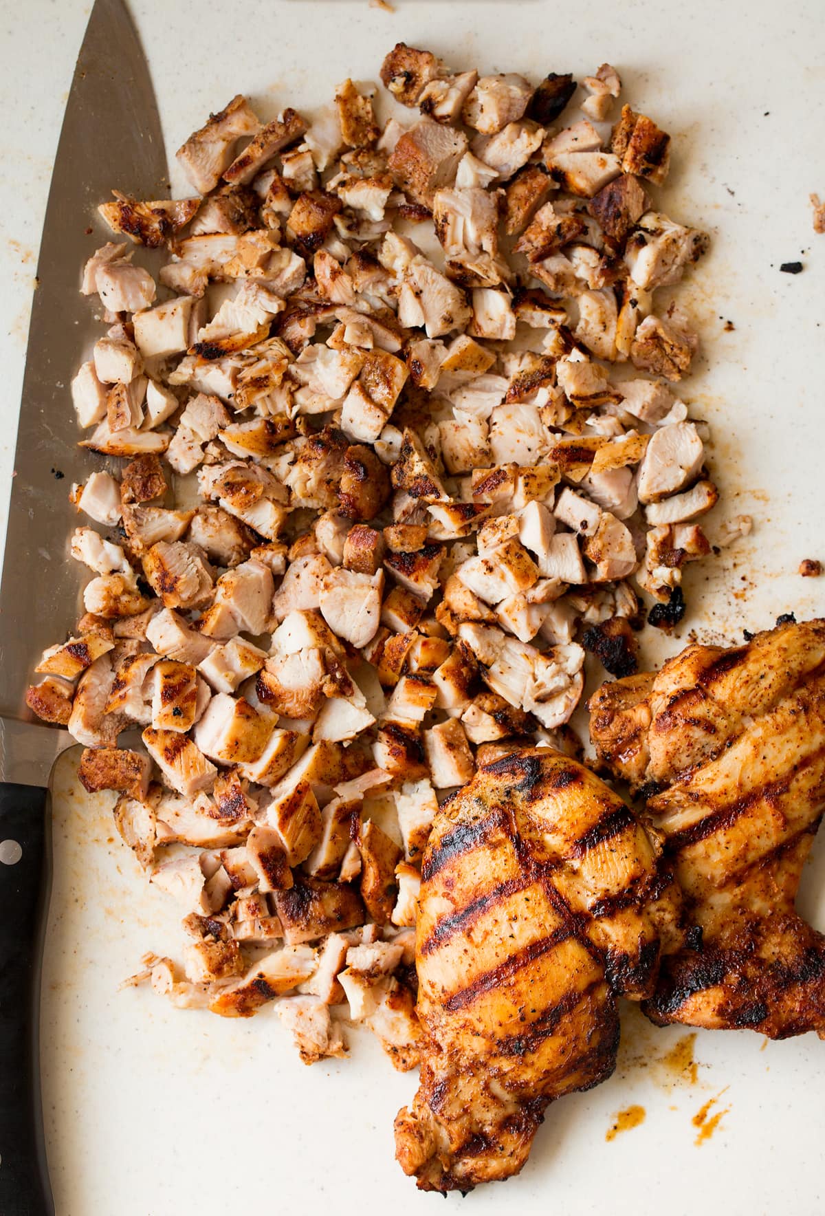 Grilled Chicken Street Tacos Chicken being diced on a cutting board into small pieces to serve in tacos.