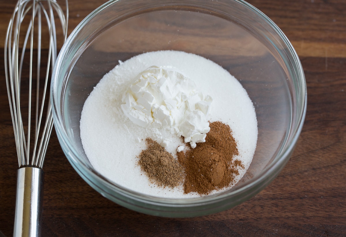 Peach Cobbler - the only peach cobbler recipe you'll ever need! I've never found better! Light and fluffy, buttery topping and perfectly sweet and juicy peach filling. #peach #cobbler #dessert #recipe Showing the steps to making peach cobbler. In a mixing bowl whisking together sugar, cinnamon, nutmeg and cornstarch.