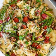 ravioli with tomatoes asparagus walnuts parmesan garlic herbs in serving bowl