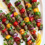 steak kebabs on platter with chimichurri
