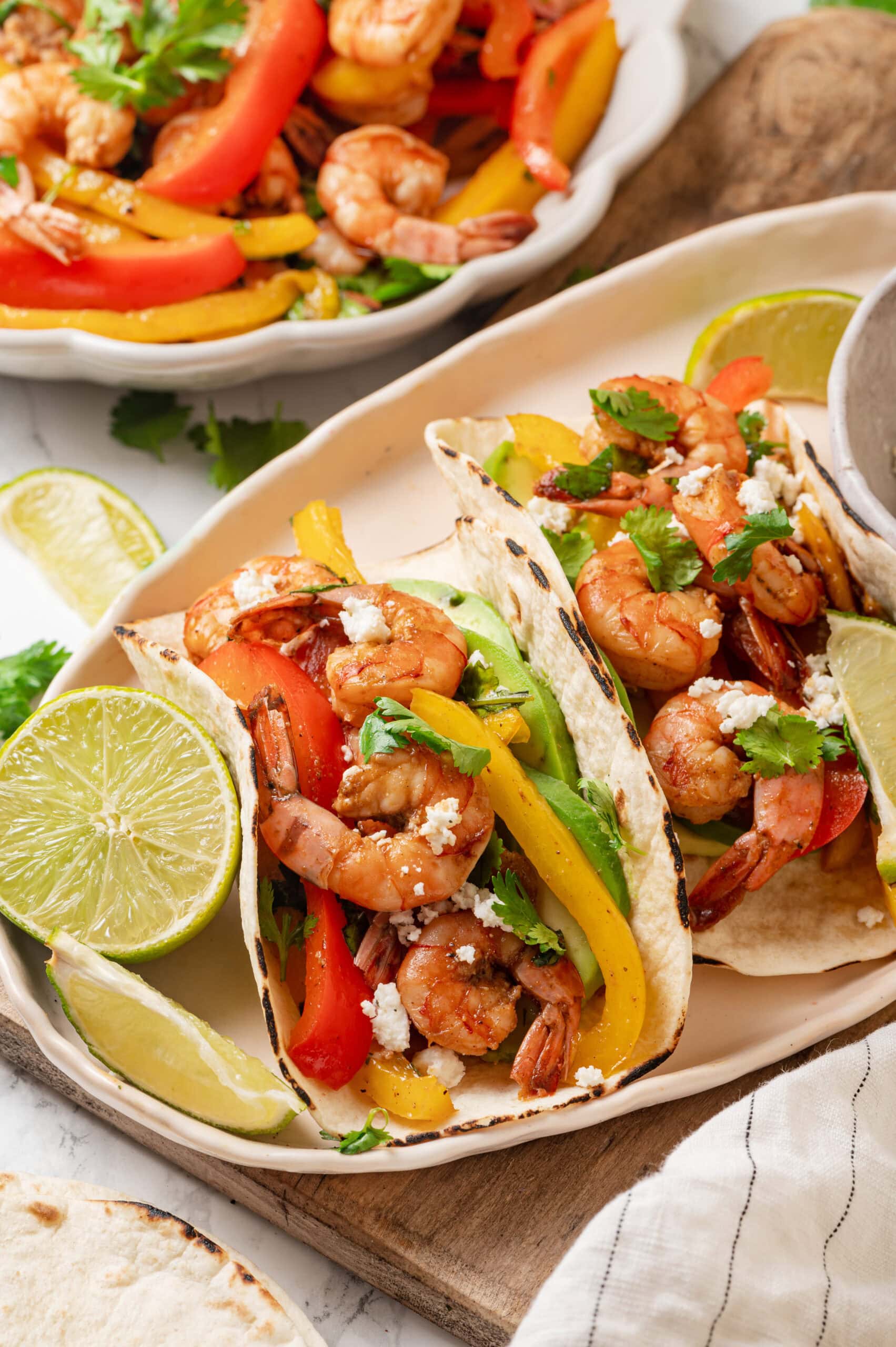 Shrimp fajitas with peppers, avocado, queso fresco and lime.