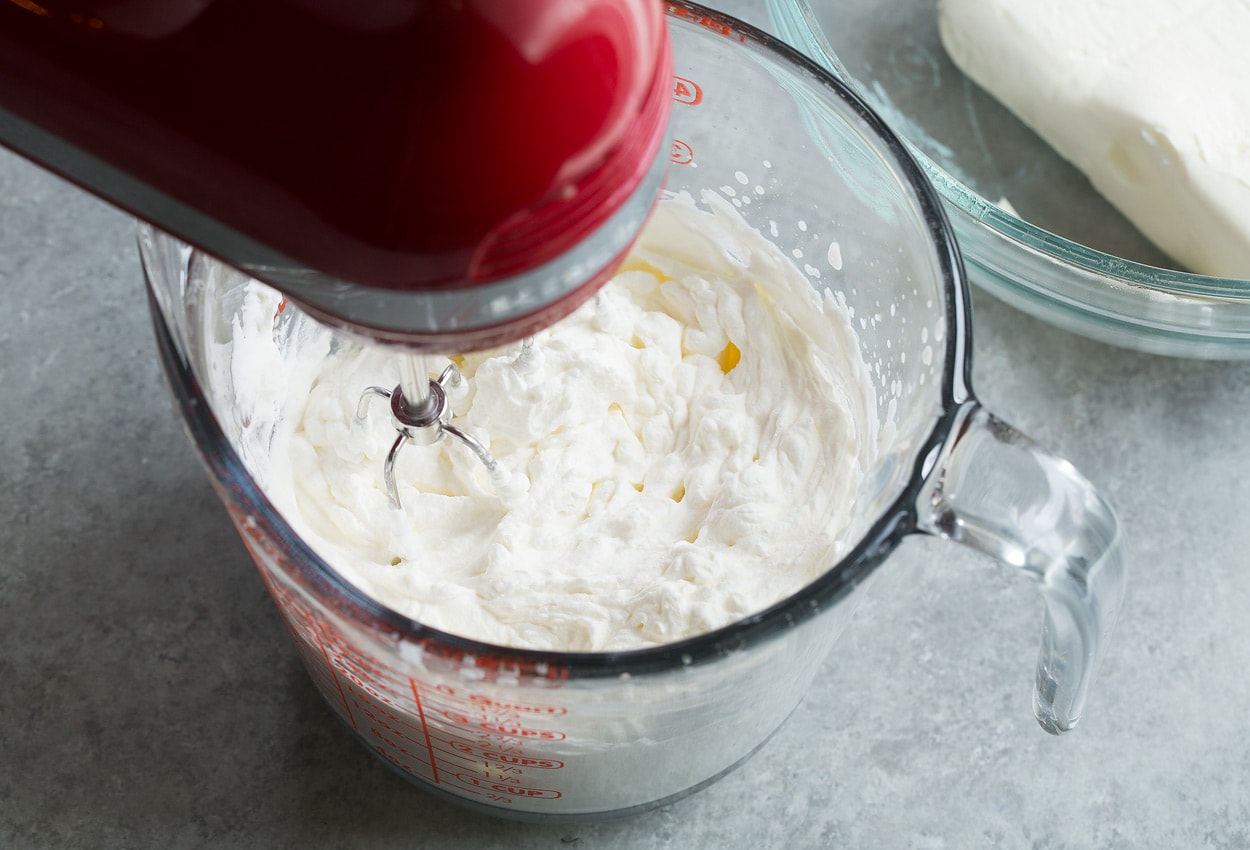Berry Cheesecake Fruit Salad whipping heavy cream in bowl