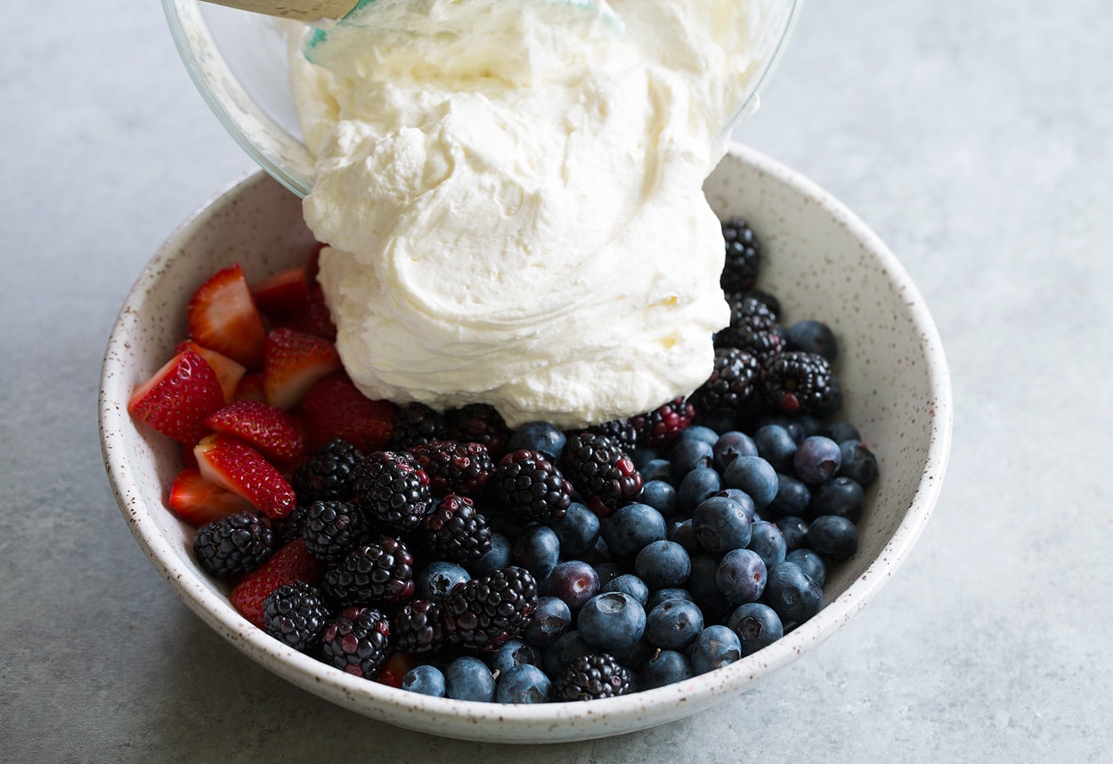 Berry Cheesecake Fruit Salad mixing berries and topping together