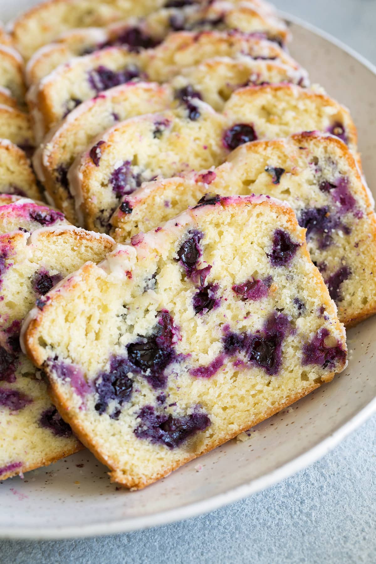 sliced loaf of Lemon Blueberry Bread on white plate