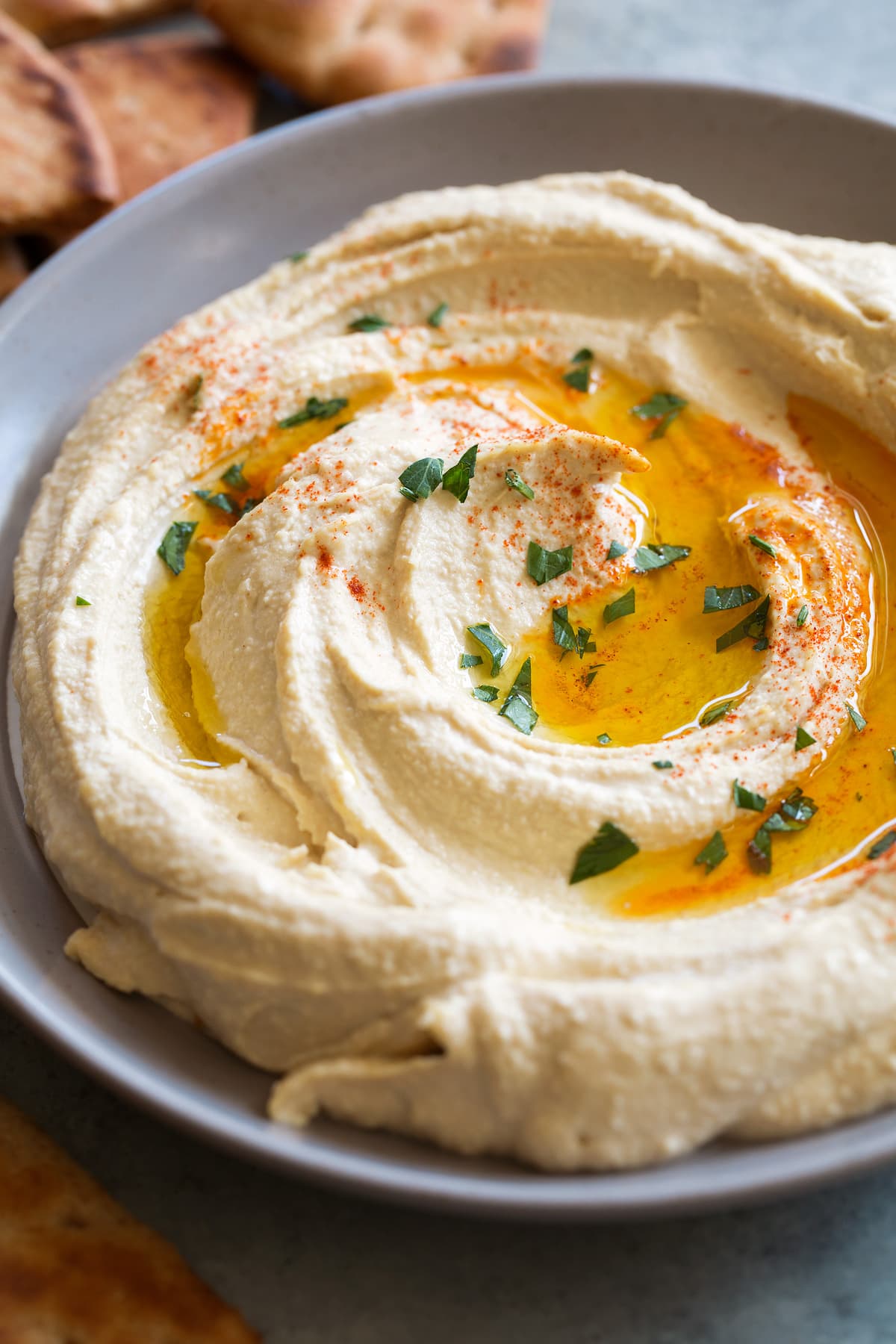 Hummus drizzled with olive oil and sprinkled with paprika in serving bowl