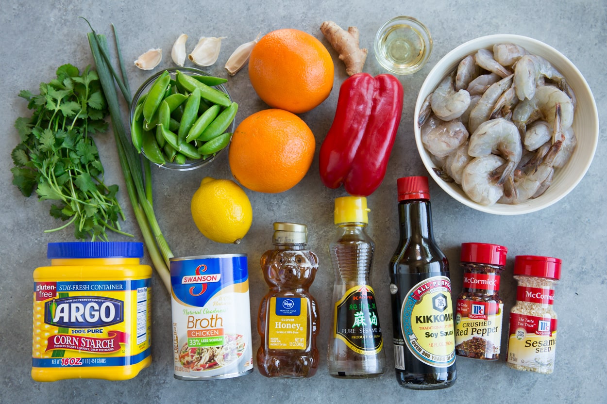Orange Garlic Shrimp ingredients shown shrimp oil bell pepper ginger oranges garlic peas green onions cilantro cornstarch broth honey sesame oil soy sauce red pepper flakes sesame seeds
