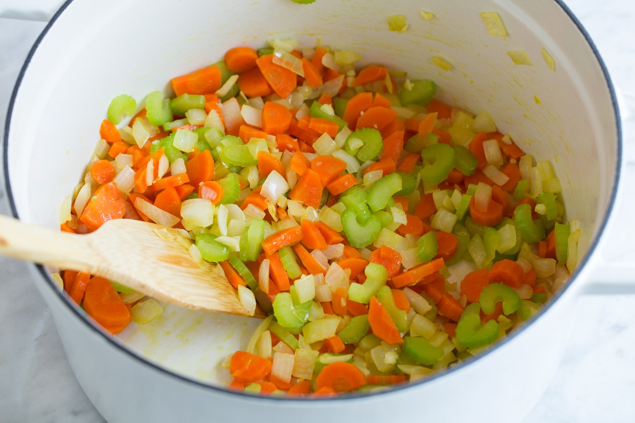 Cabbage Soup Showing how to make cabbage soup. Sauteeing carrots, onions and celery in a large white pot.