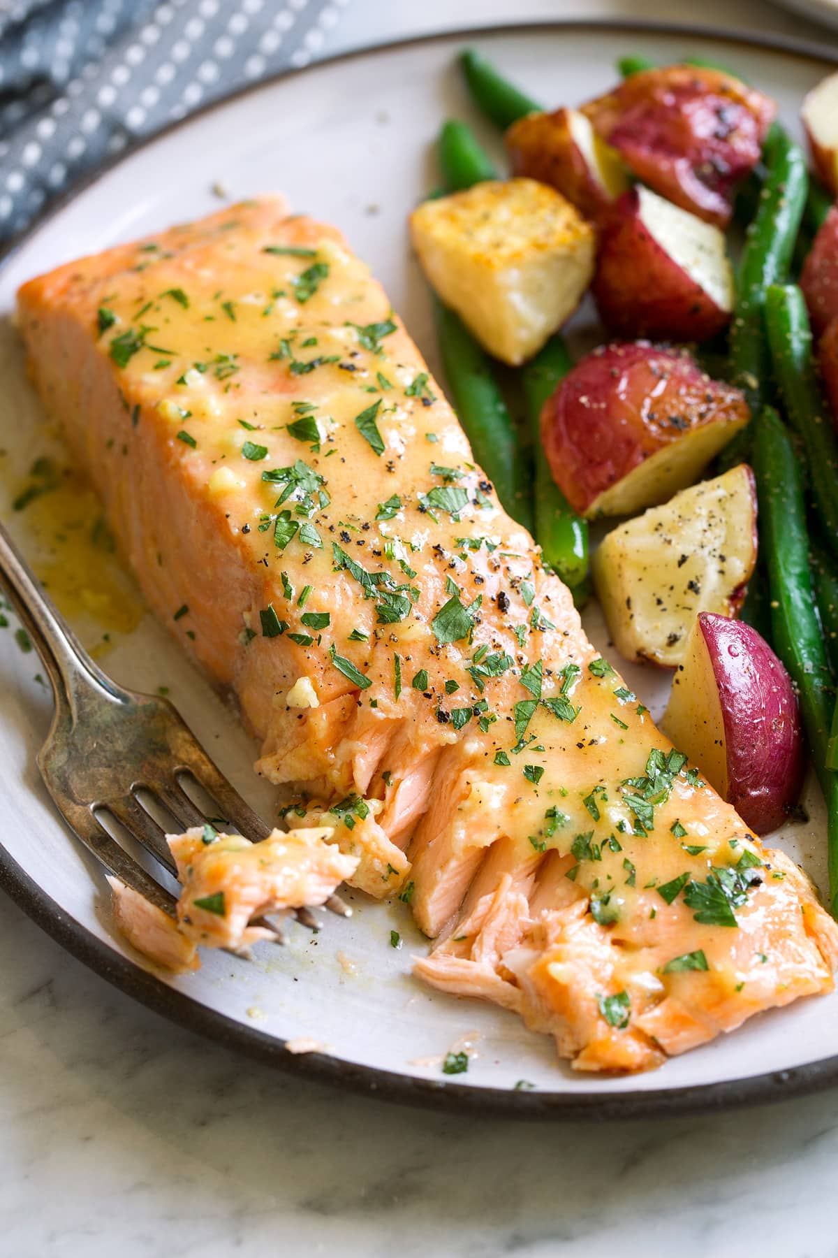 Baked Salmon with Buttery Honey Mustard Sauce Flaked salmon fillet on a serving plate.