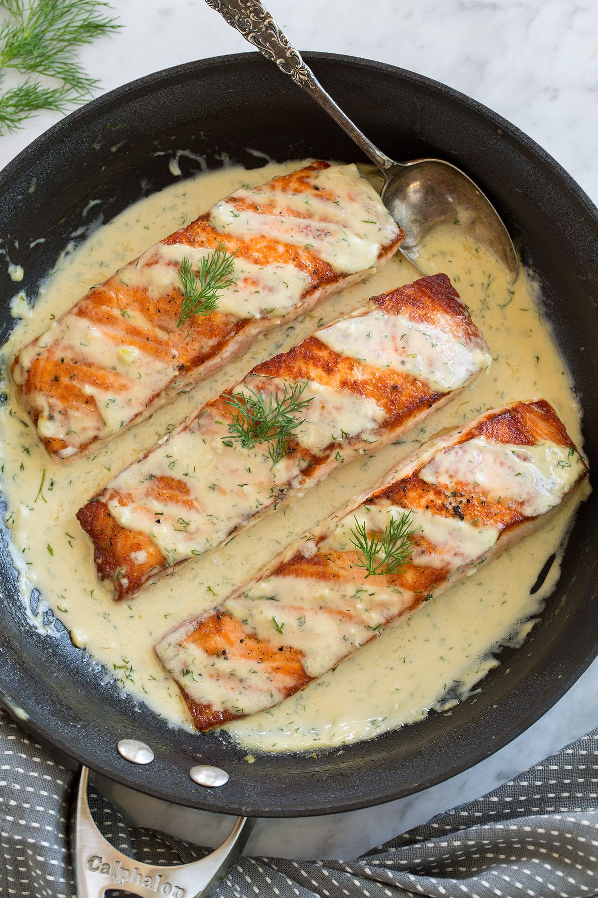 Salmon with Creamy Dijon Sauce Three salmon fillets in a skillet with a creamy dijon sauce.