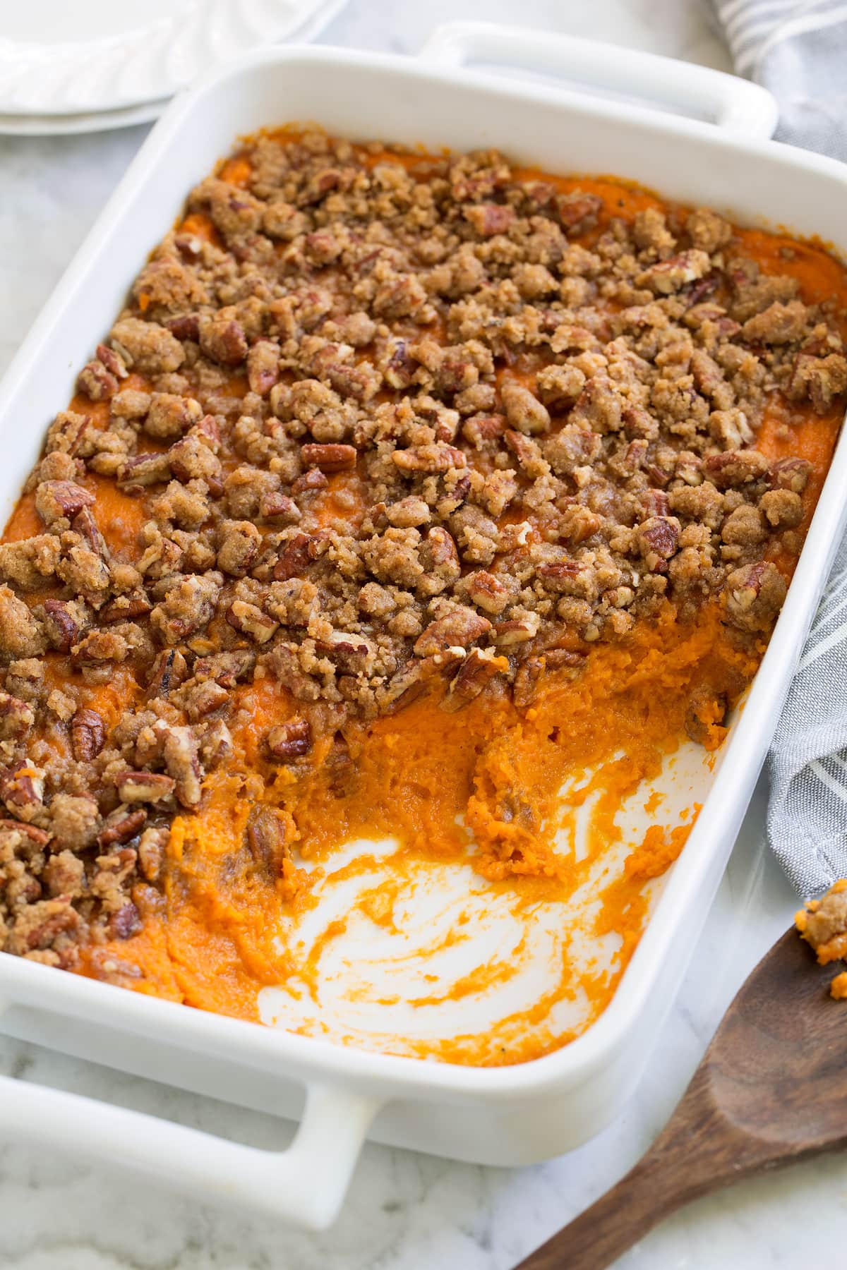 Sweet Potato Casserole Sweet Potato Casserole with a cinnamon pecan crumble on top, served in a white casserole dish.