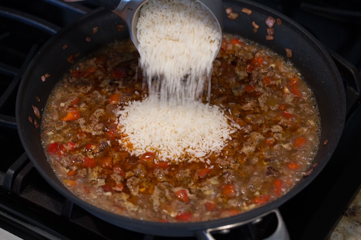 Chimichurri Beef and Rice Adding rice to skillet to make Chimichurri Beef and Rice.