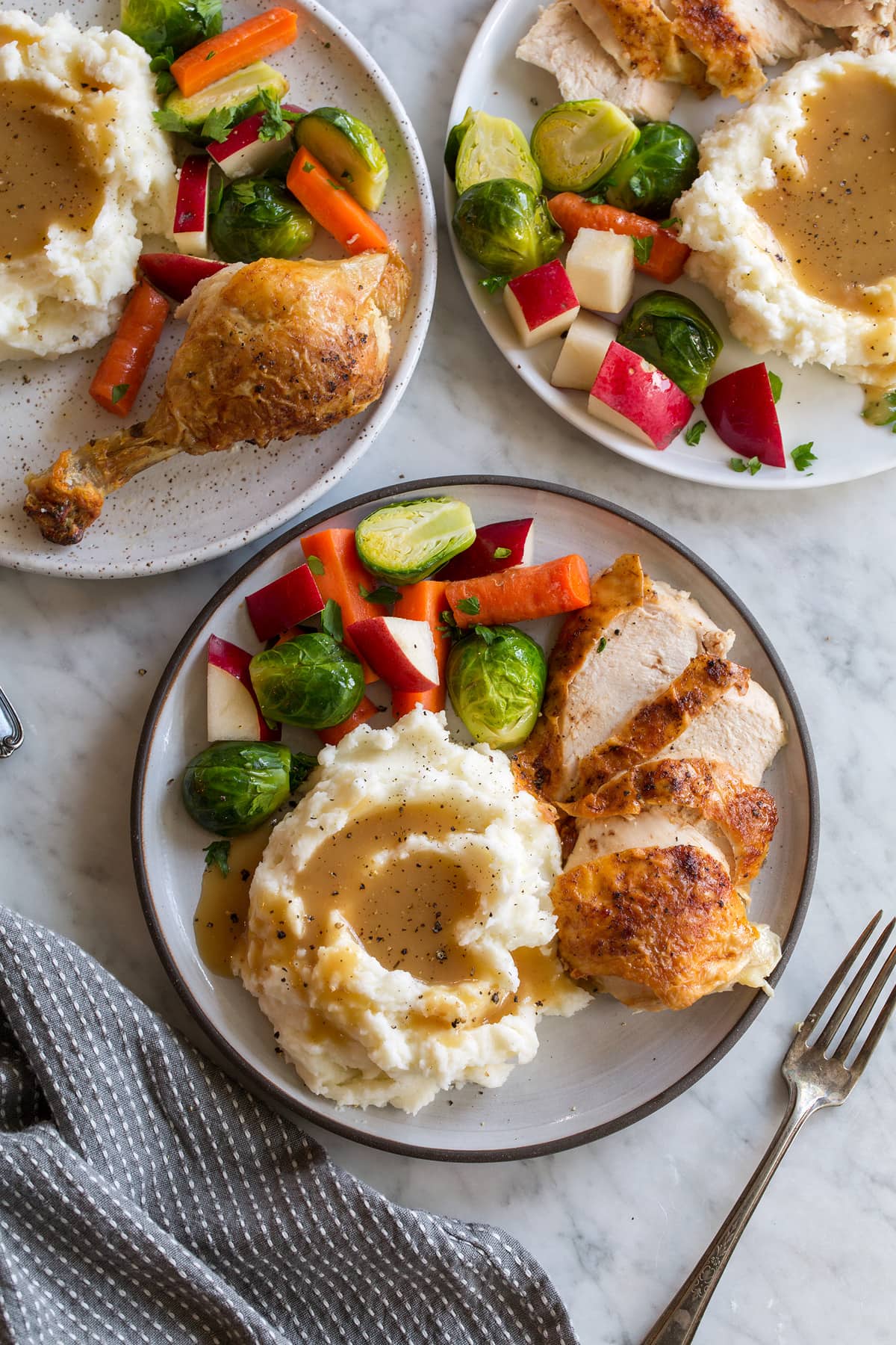 Roast chicken with mashed potatoes, gravy, and steamed veggies.