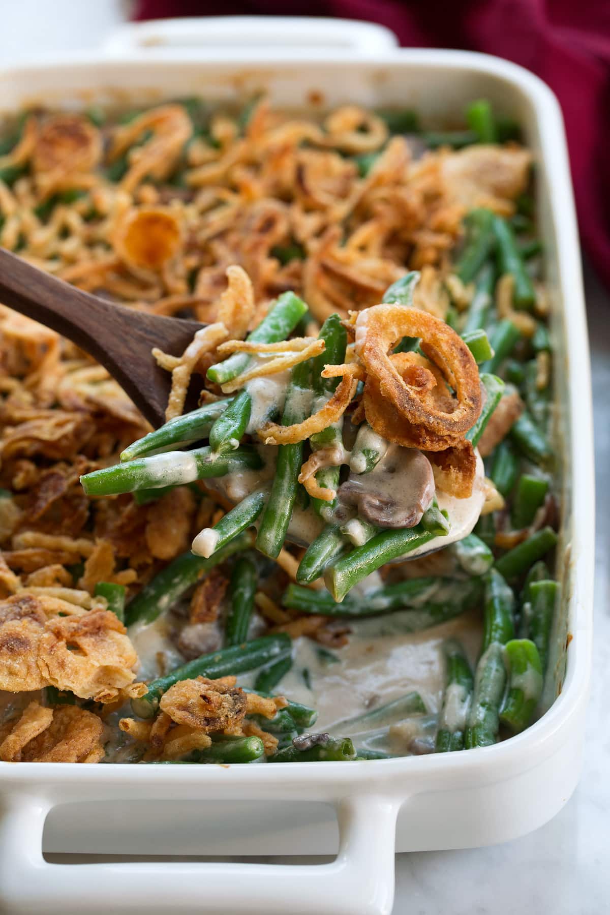 Green Bean Casserole Close up image of a scoop of green bean casserole. Fresh green beans are coated with a creamy mushroom filling and topped with French's fried onions.