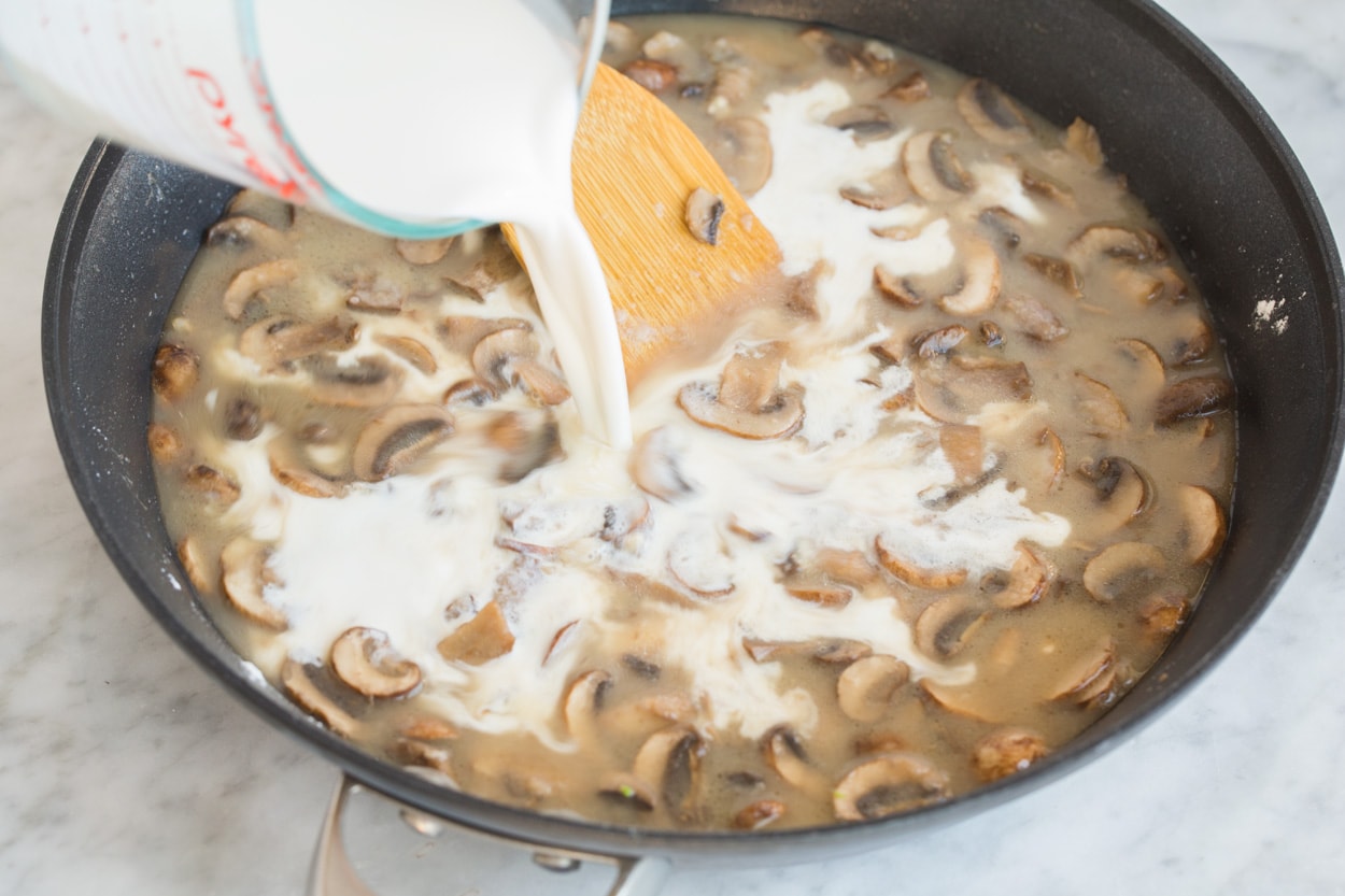 Green Bean Casserole Mixing half and half and chicken broth into mushroom mixture for Green Bean Casserole.