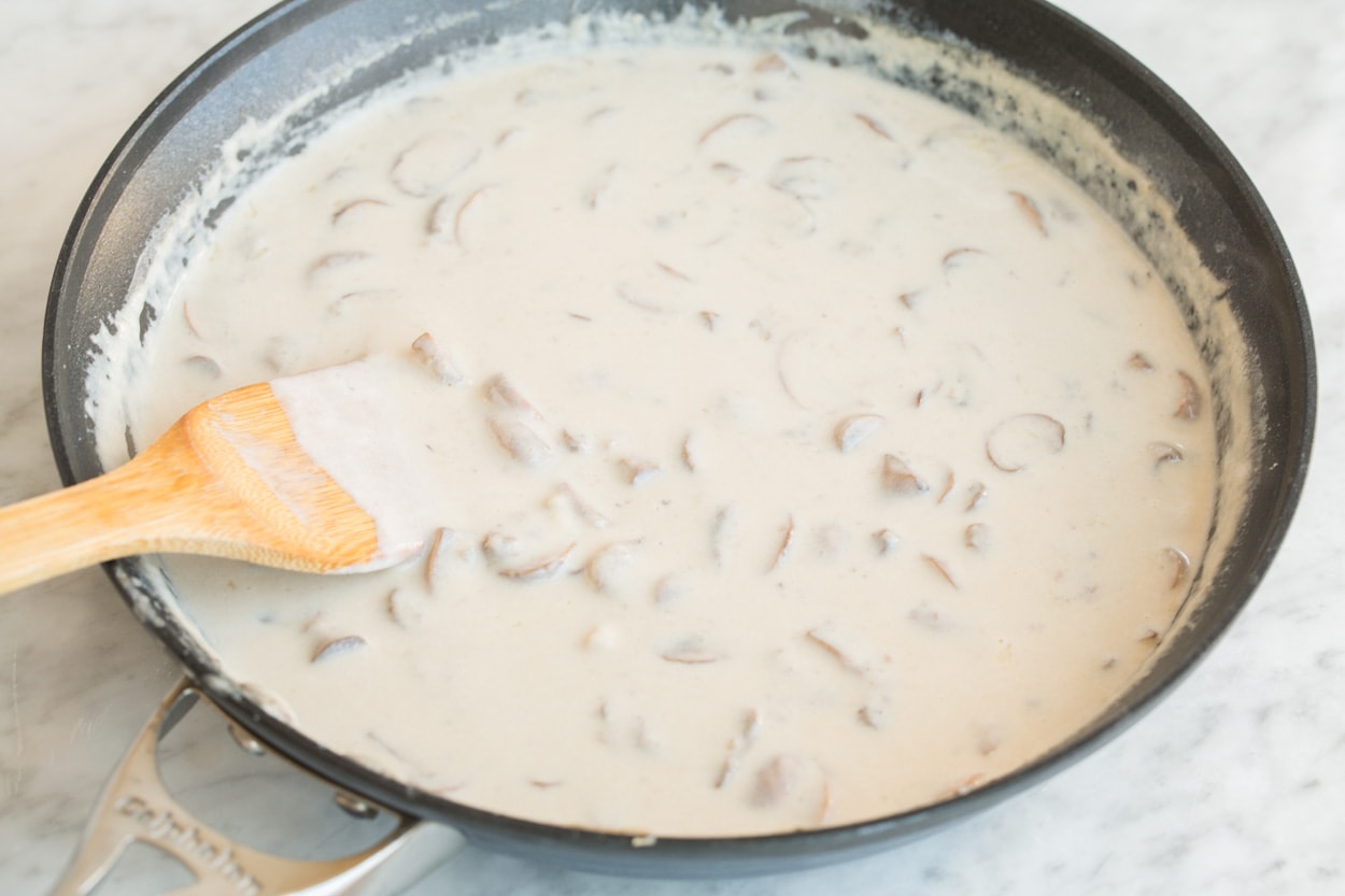 Green Bean Casserole Finished creamy filling in a large skillet set over a marble surface, for Green Bean Casserole.
