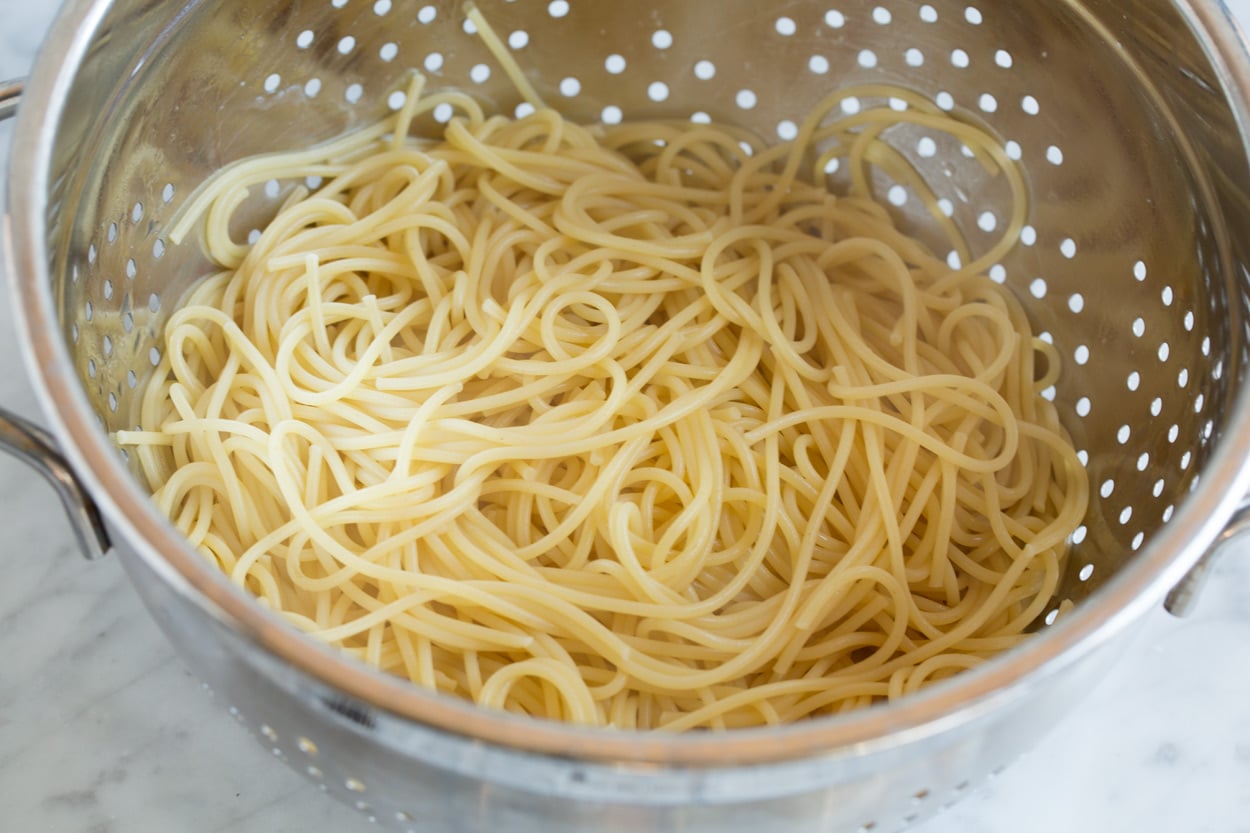 cooked spaghetti noodles in metal colander