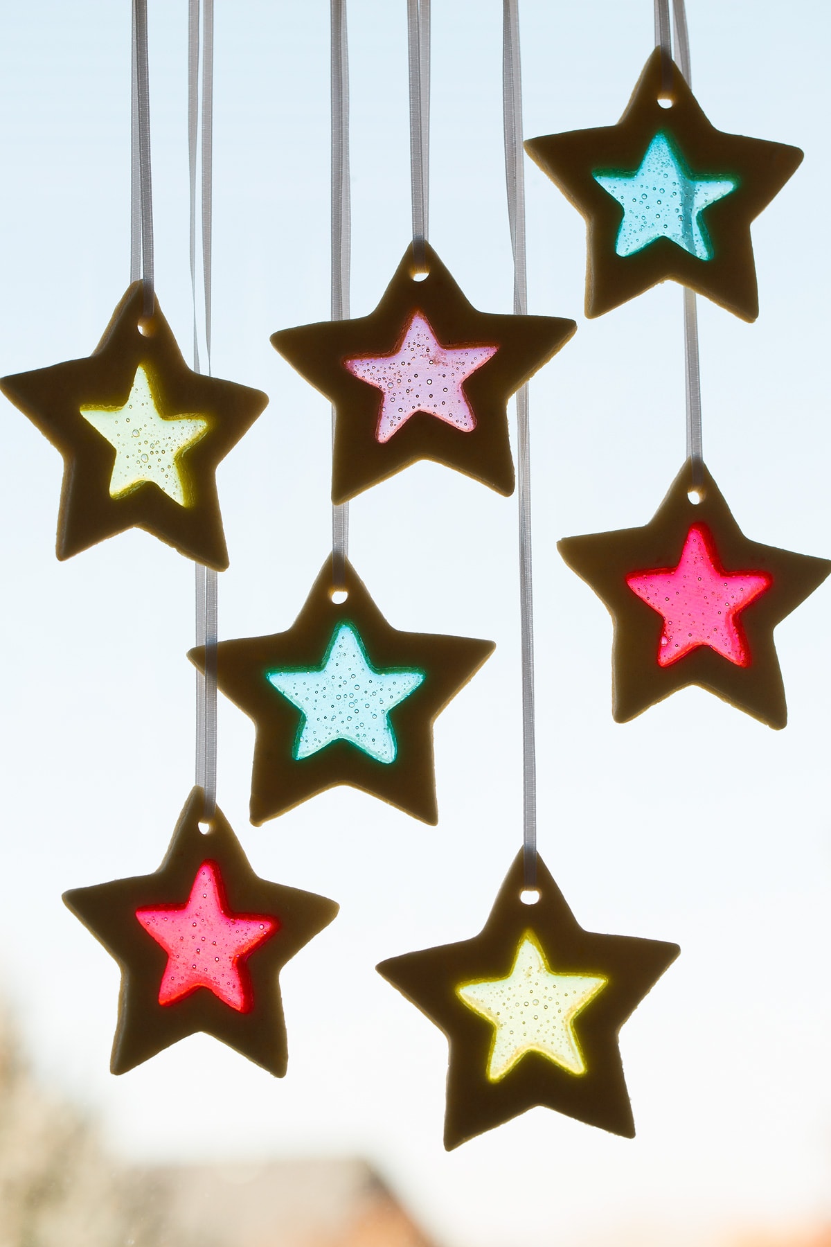 Stained Glass Cookies Stained Glass Cookies hanging from ribbon in a window.