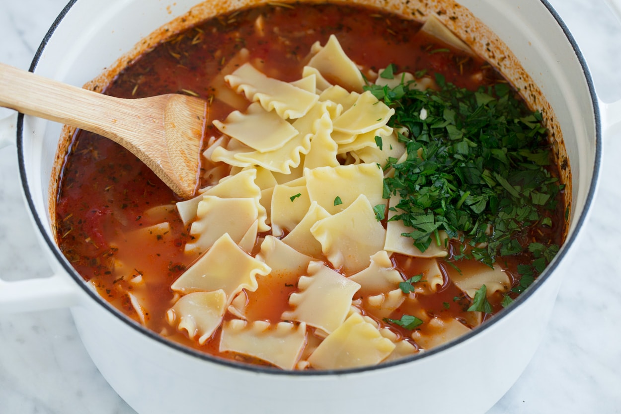 Lasagna Soup Stirring broken cooked lasagna noodles and parsley into lasagna soup.