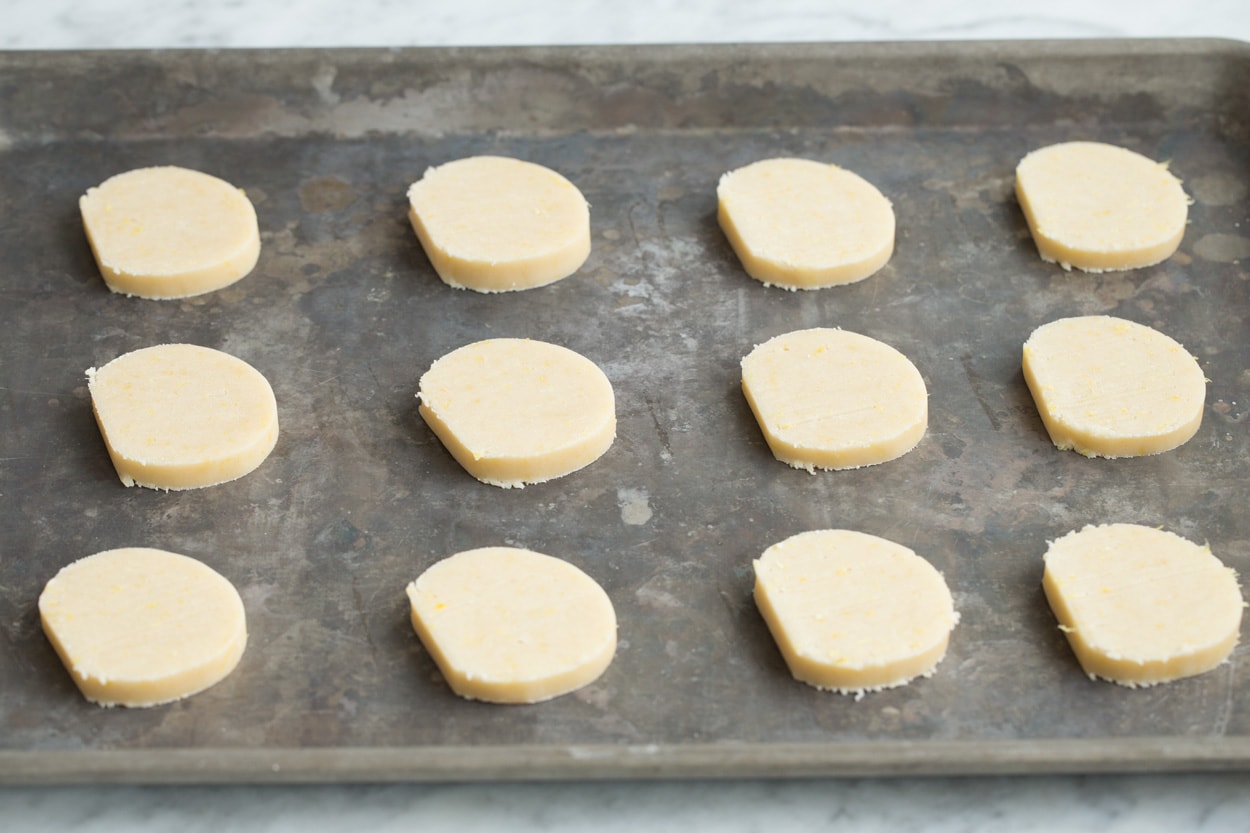 Lemon Shortbread Lemon shortbread cookie dough slices on baking sheet before baking.