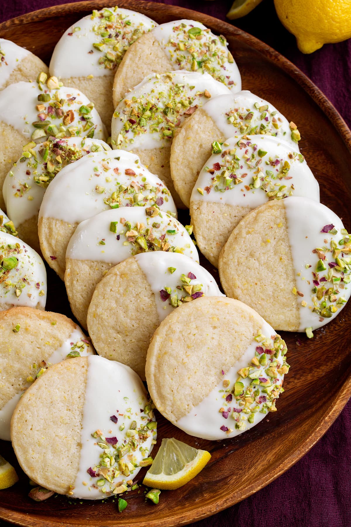Lemon Shortbread Cookies Shortbread cookies on a wooden serving plate. Flavored with lemon, white chocolate and pistachios.
