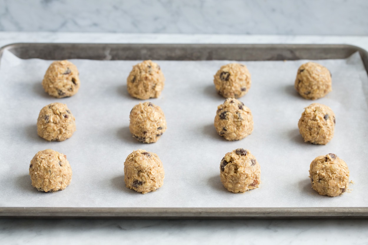 BEST Oatmeal Cookies! Oatmeal cookie dough balls on parchment paper lined baking sheet before baking.