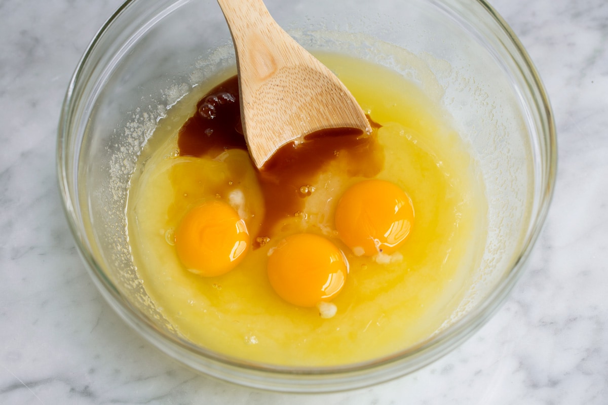 Best Cocoa Brownies Adding eggs and vanilla to mixing bowl to make brownies.
