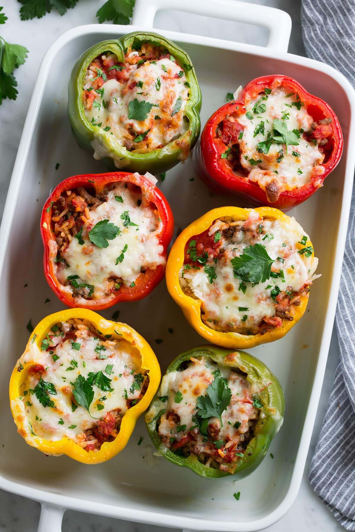 Stuffed Peppers Overhead image of six stuffed peppers in a white baking dish.