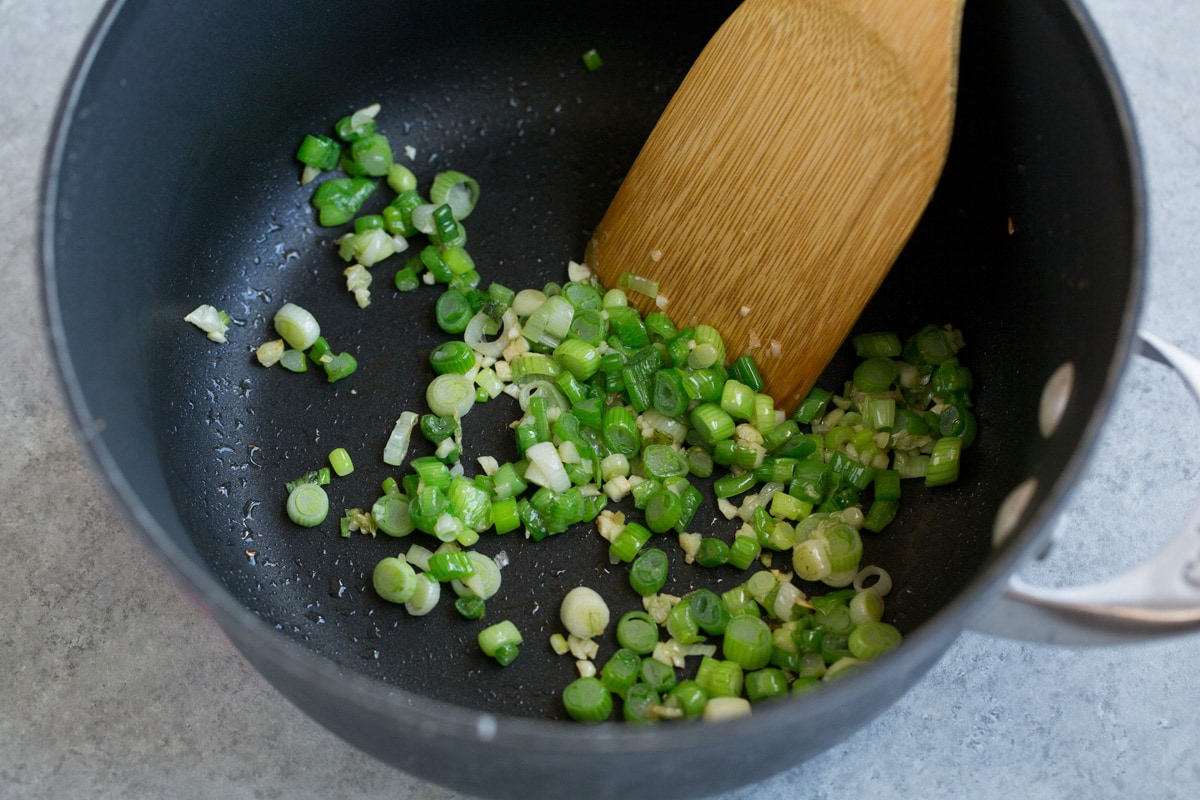 Cilantro Lime Rice Showing how to make cilantro lime rice, starting by sauteing green onion and garlic in a saucepan.
