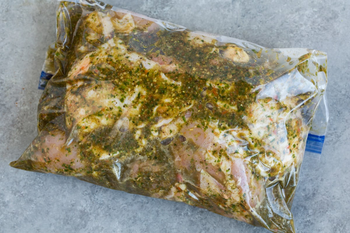 Perfect Jerk Chicken Soaking chicken pieces in a resealable bag with marinade.