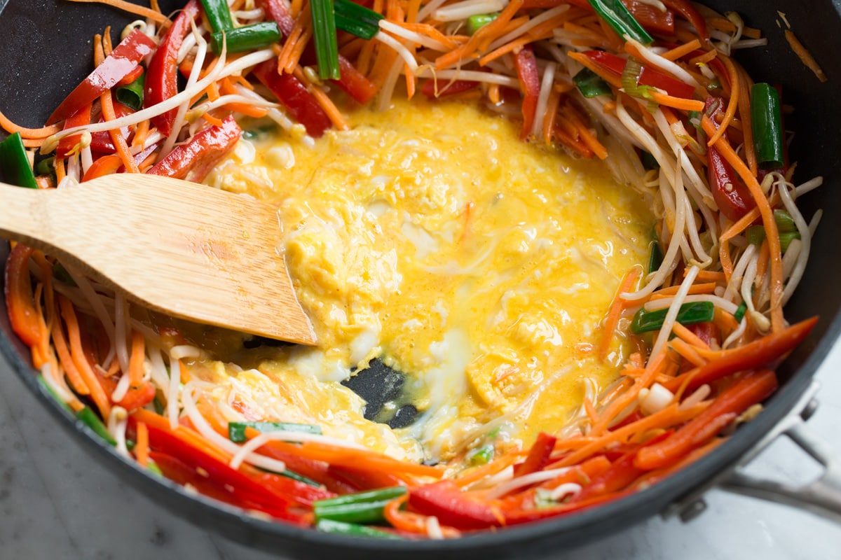 Pad Thai (with Chicken or Shrimp) Scrambling and cooking eggs in a center of wok for pad thai.